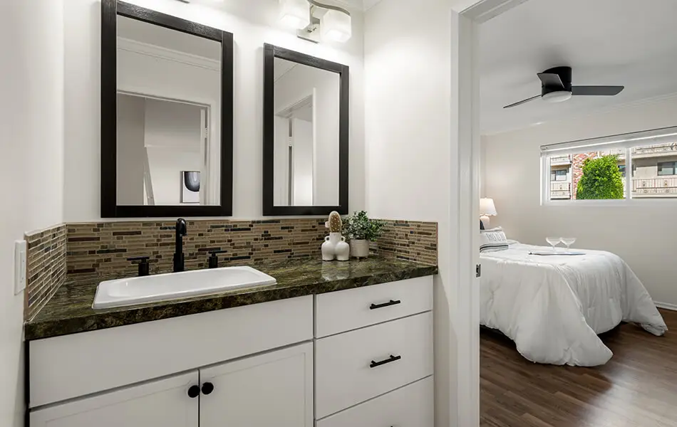 Bathroom vanity with granite counter and mosaic tile backsplash at 11550 Nebraska Ave westside condo