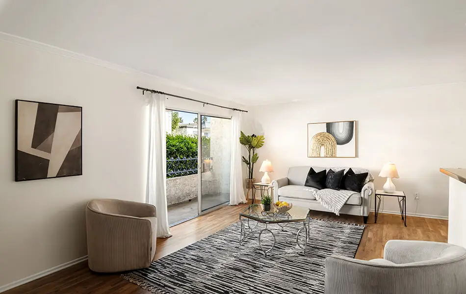 Living room with sliding glass door to patio and hardwood floors at 11550 Nebraska Ave West LA condo