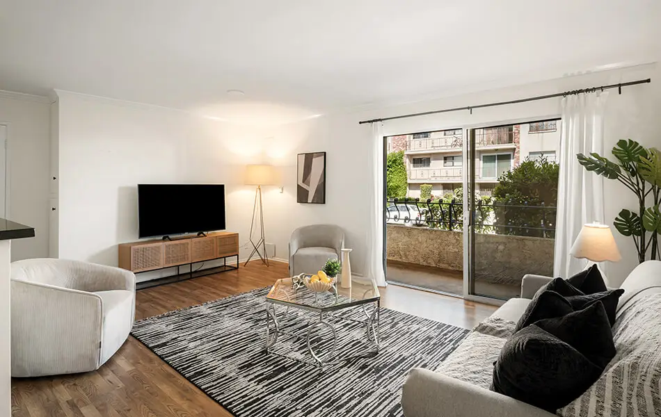 Living room with TV console hardwood floors and balcony sliding door at 11550 Nebraska Ave West LA condo
